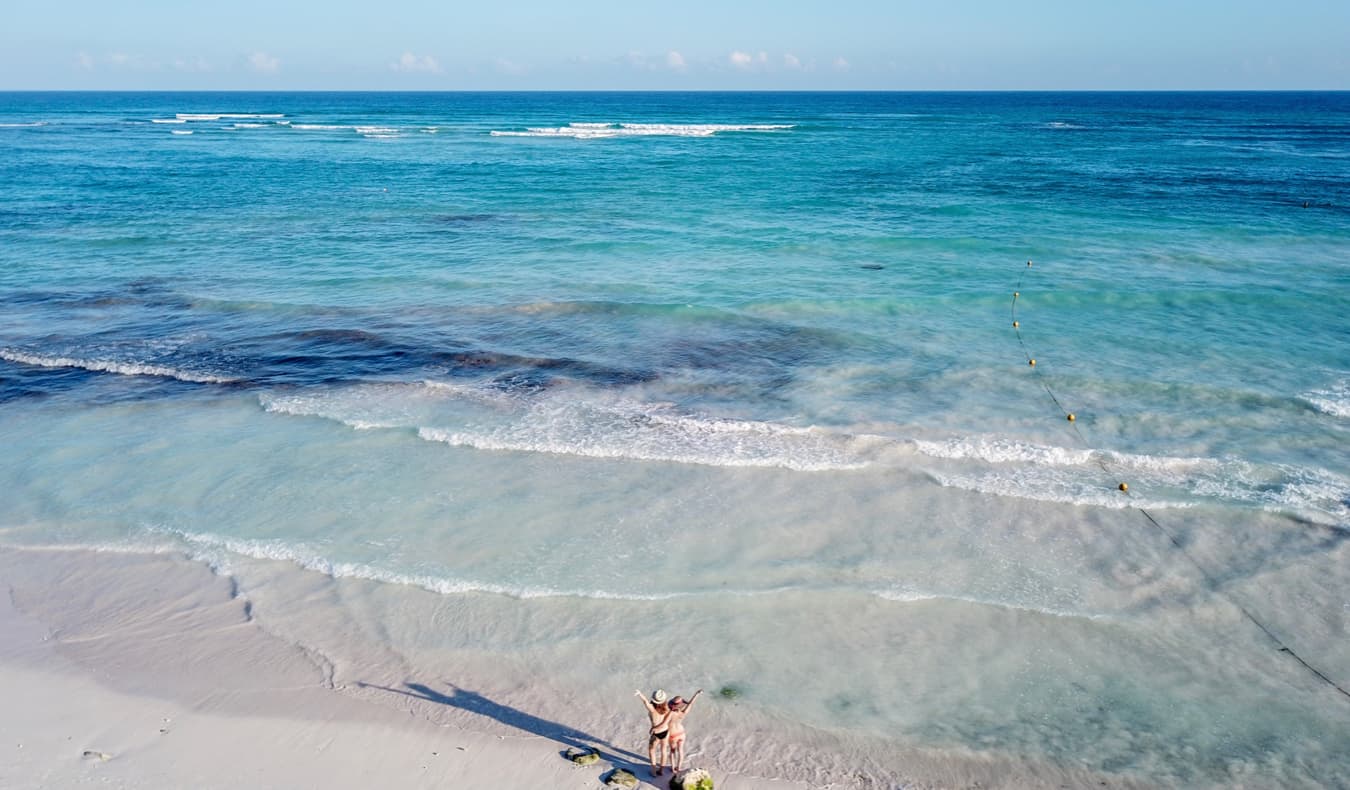 Solo female traveler Kristin Addiss in Mexico with a friend on the beach looking out over the water